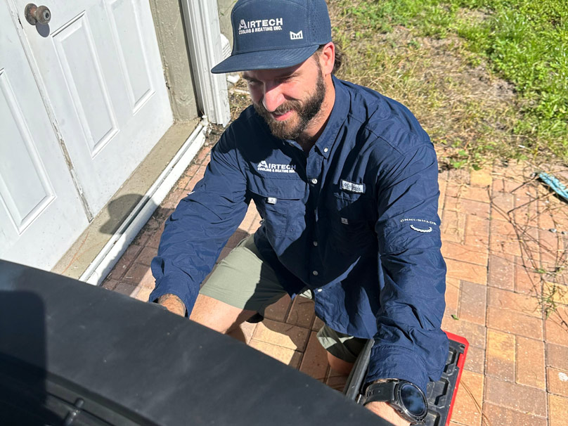 Airtech service tech checking air conditioner